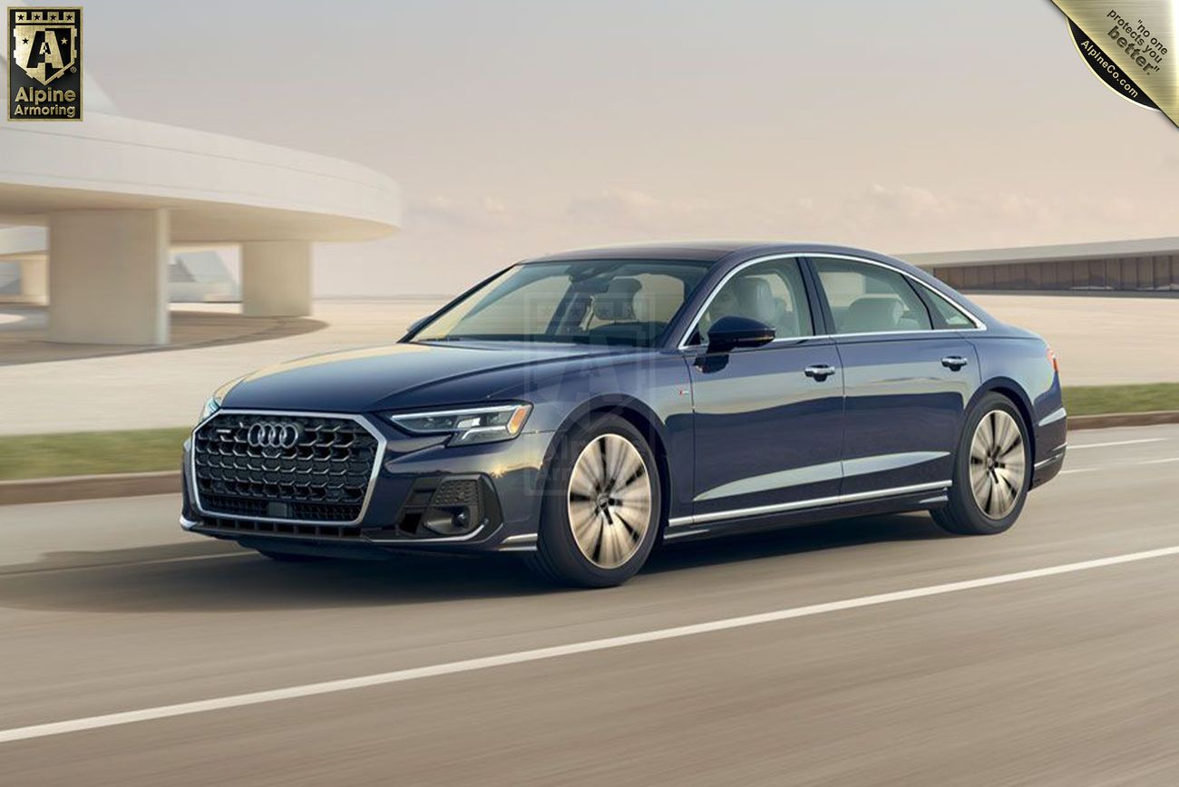 A sleek, dark blue armored Audi A8 sedan driving on a paved road with modern architecture visible in the background.
