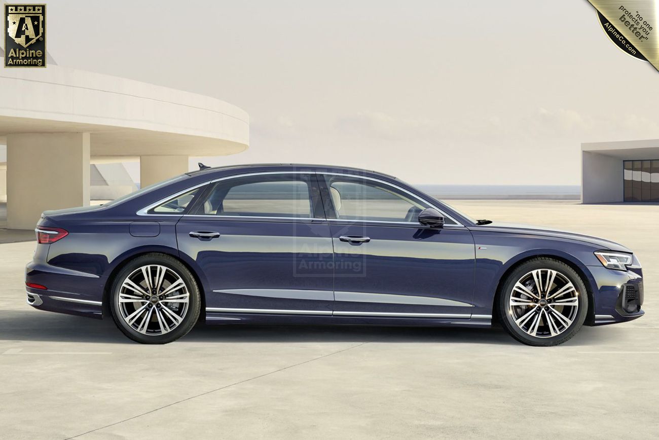 A dark blue armored Audi A8 luxury sedan is parked on a spacious, modern concrete area with a clear sky in the background.