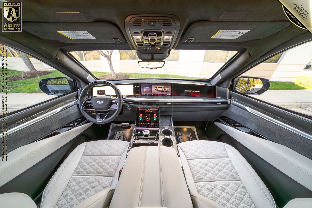 Luxury armored Cadillac Escalade ESV SUV interior with quilted leather seats, panoramic sunroof, and premium dashboard displaying Alpine Armoring's comfort preservation in bulletproof vehicles.
