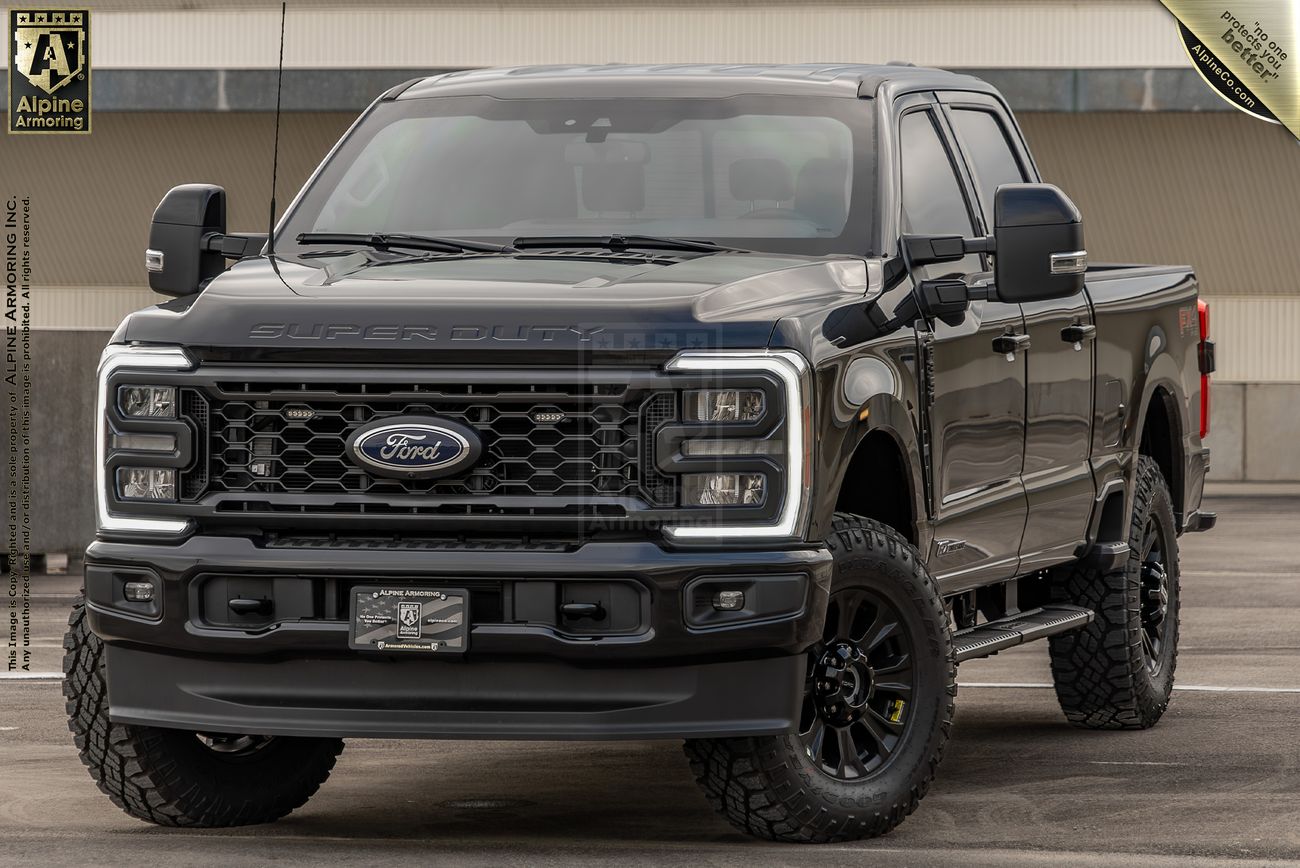 A black Ford Lightning Super Duty pickup truck is parked in an outdoor lot. The truck features large off-road tires, a prominent front grille, and visible logos for Ford and aftermarket parts.