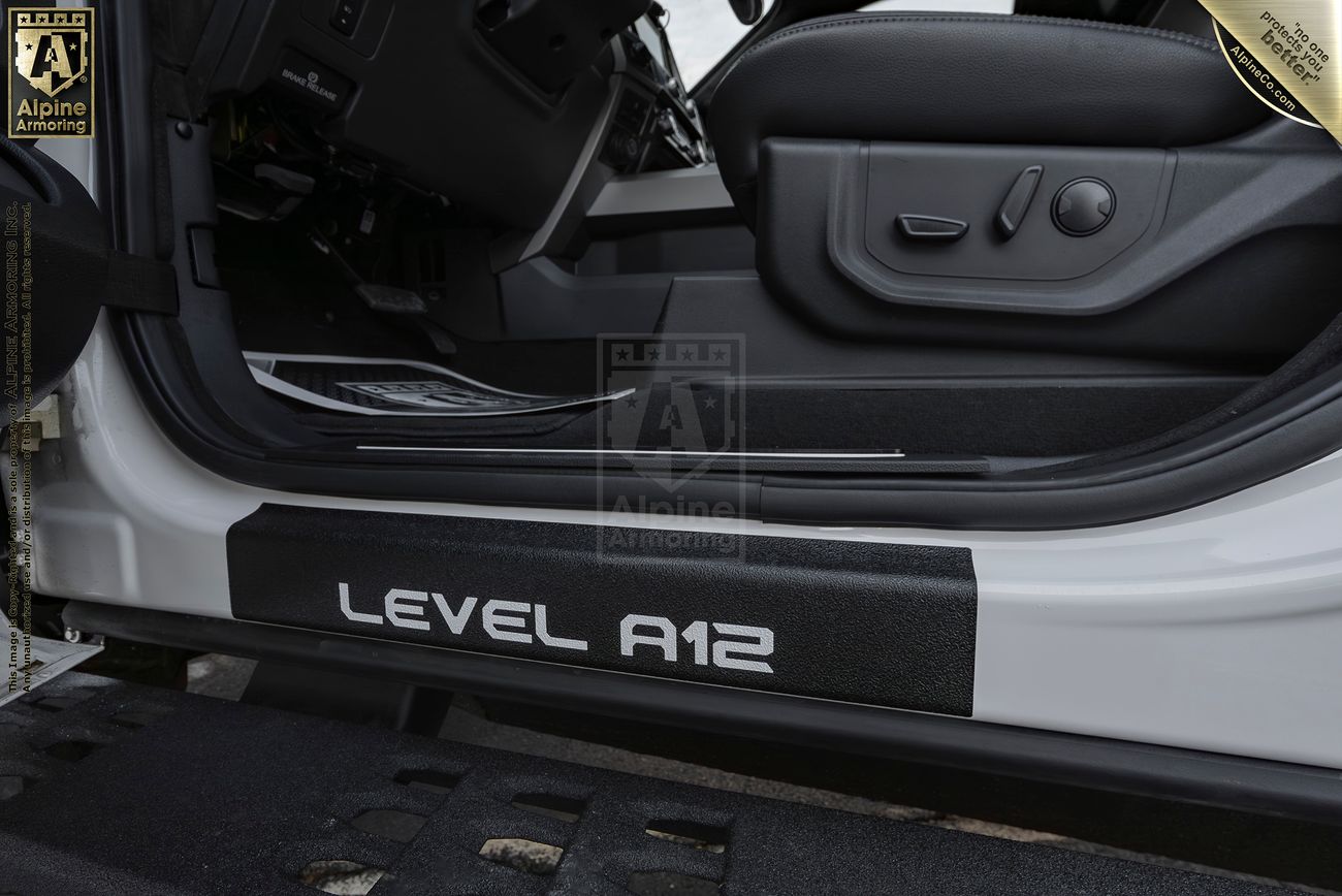 Close-up of a Mastiff interior showcasing the door sill with the text "LEVEL A12" and seat adjustment controls. 