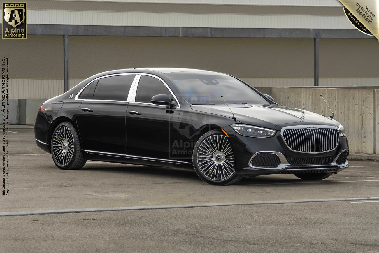 A black luxury armored Mercedes Maybach S 580 sedanwith tinted windows parked in an urban area. The vehicle has customizable wheels and a sleek design.