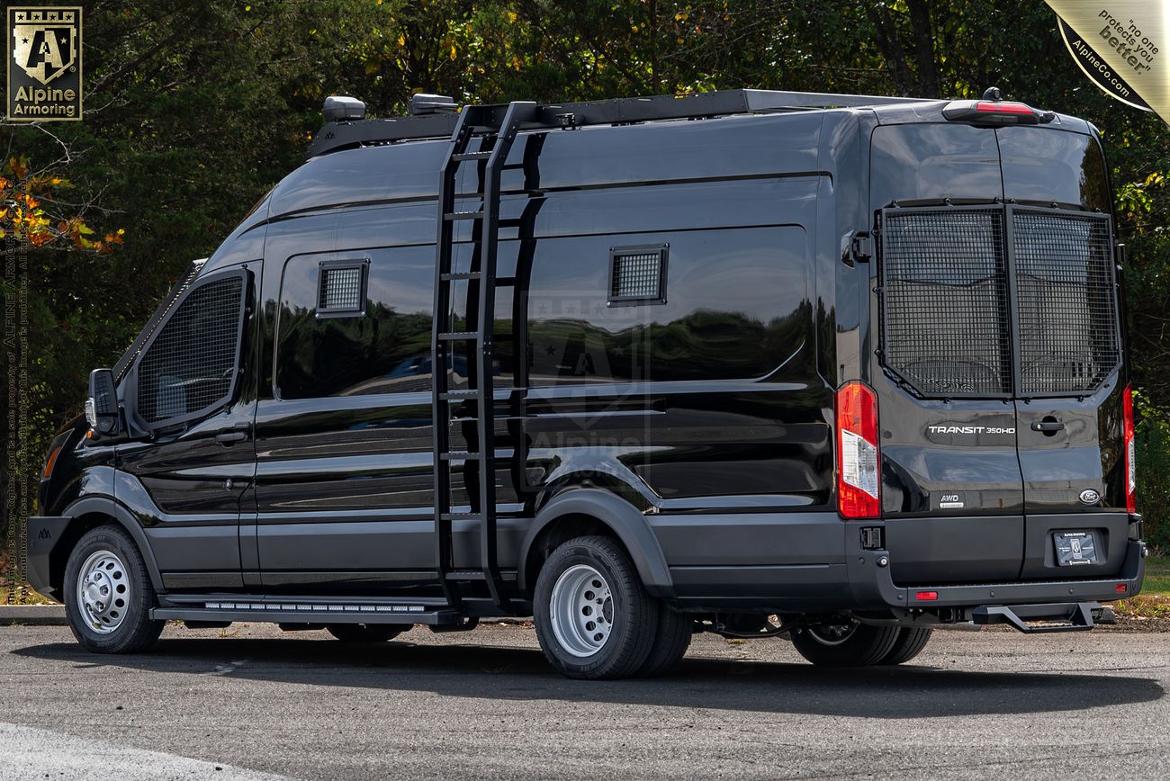 A black Pointer van with off-road upgrades including roof rack, ladder, and rear cage, parked on a road with trees in the background.