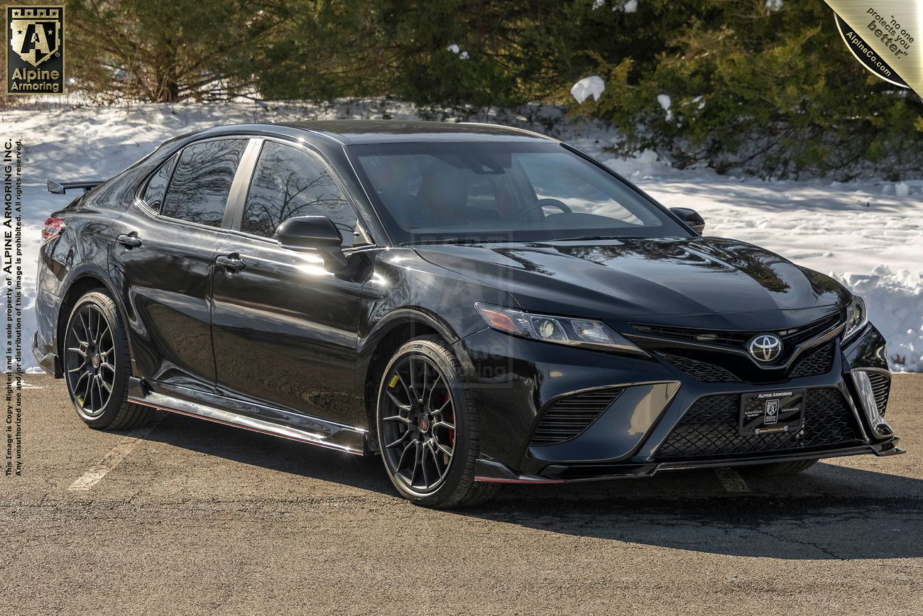 Front view, from the right, of an armored Toyota Camry TRD sedan in a snowy environme