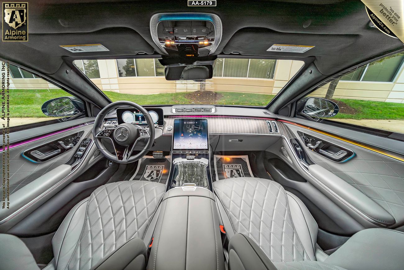 Front interior view of armored Mercedes-Benz S580 showing its grey seats and wood dash 