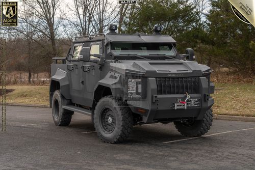 Pit-Bull armored tactical vehicle with angular armor plating, roof-mounted turret, and heavy-duty off-road tires.