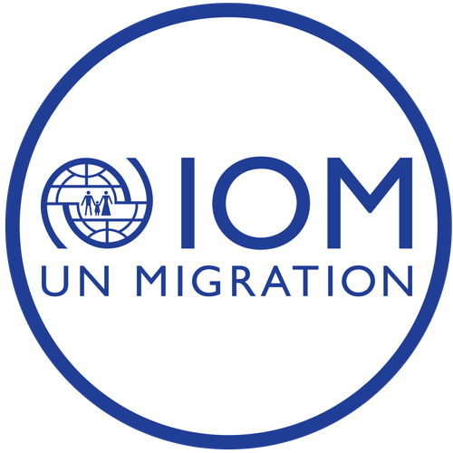 IOM UN Migration logo with blue text and a circular emblem featuring a globe and silhouettes of two people walking, all enclosed in a blue-bordered circle.